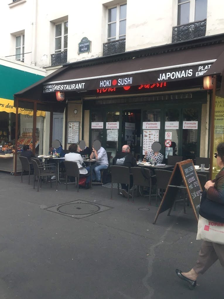 Devanture d'un restaurant avec une terasse et des clients assis