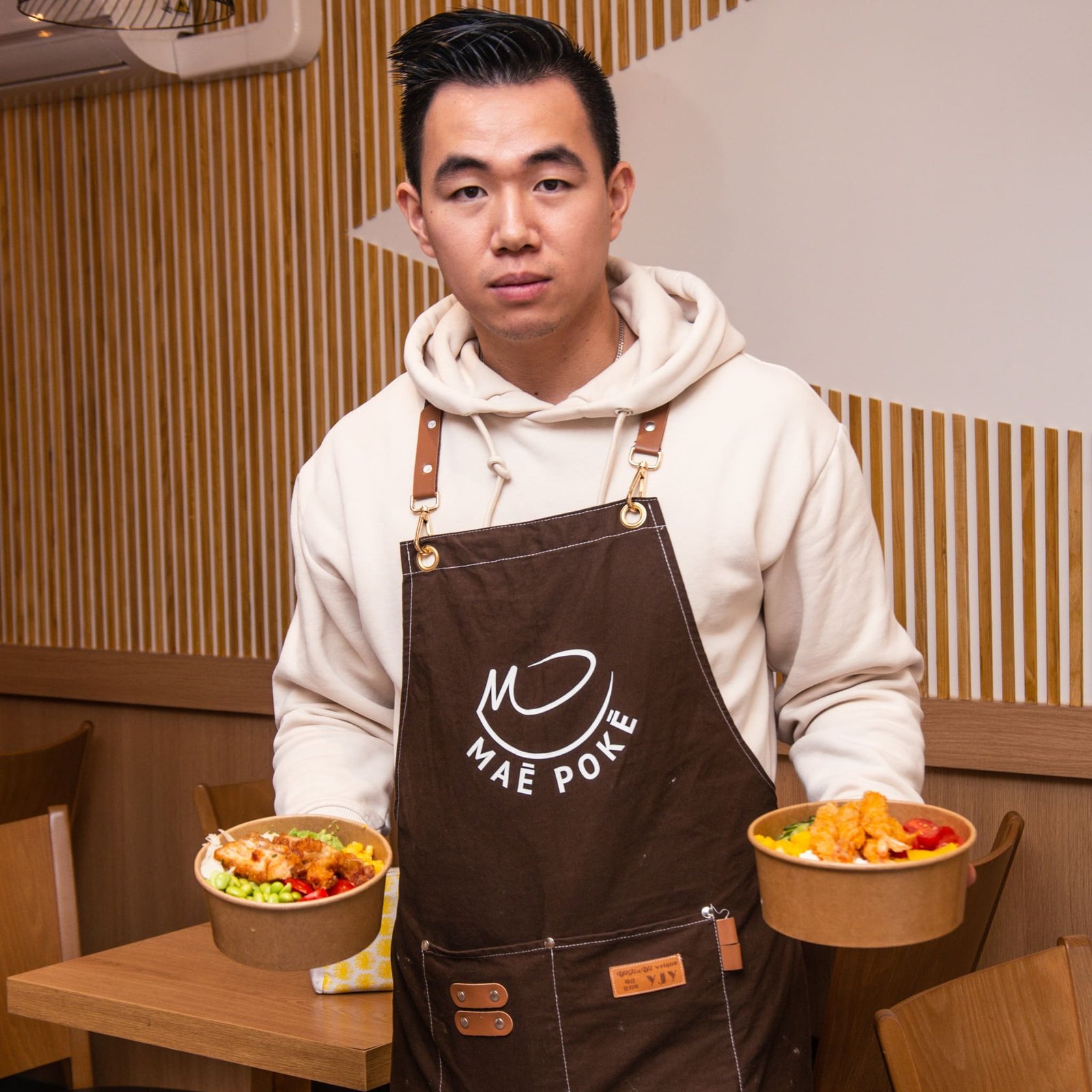 Serveur tenant un poké bowl dans chaque main